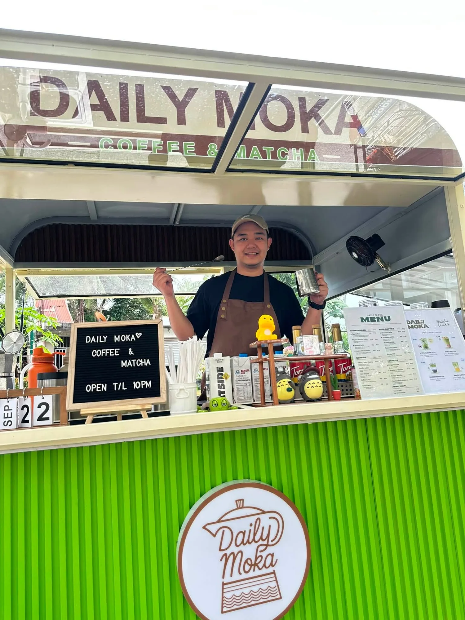 A barista behind the counter of the Daily Moka coffee cart