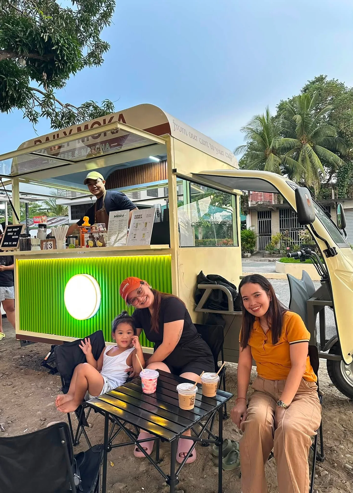 A group sharing iced drinks beside the Daily Moka coffee cart